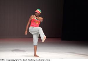 Primary view of [Photograph of a woman in casual clothes dancing on stage]