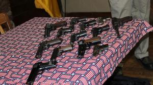 Primary view of [Handguns displayed on flag tablecloth, January 13, 2018]