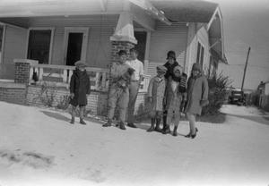 Primary view of [Photograph of individuals posing in a snowy lawn]