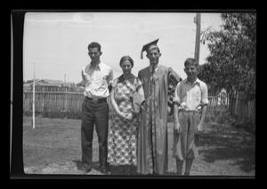 Primary view of [John Williams in graduation attire with his family]