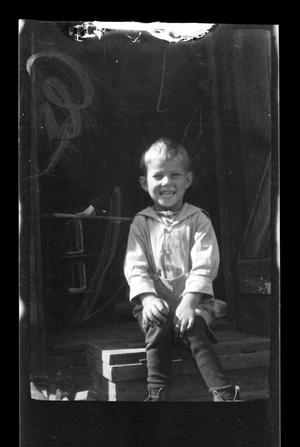 Primary view of [Charles Williams sitting on a porch]