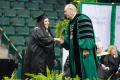Photograph: [President Neal Smatresk on stage with an Undergraduate Student]