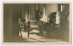 Primary view of [Photo of Byrd Williams Jr. at a table, from the Byrd Williams Jr. album, 1907-1920]